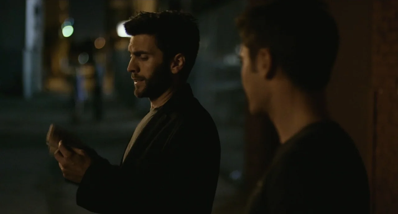 We Are Your Friends (2015) movie still: medium — Two men stand on a dark city street at night under ambient lighting. One man in the foreground…