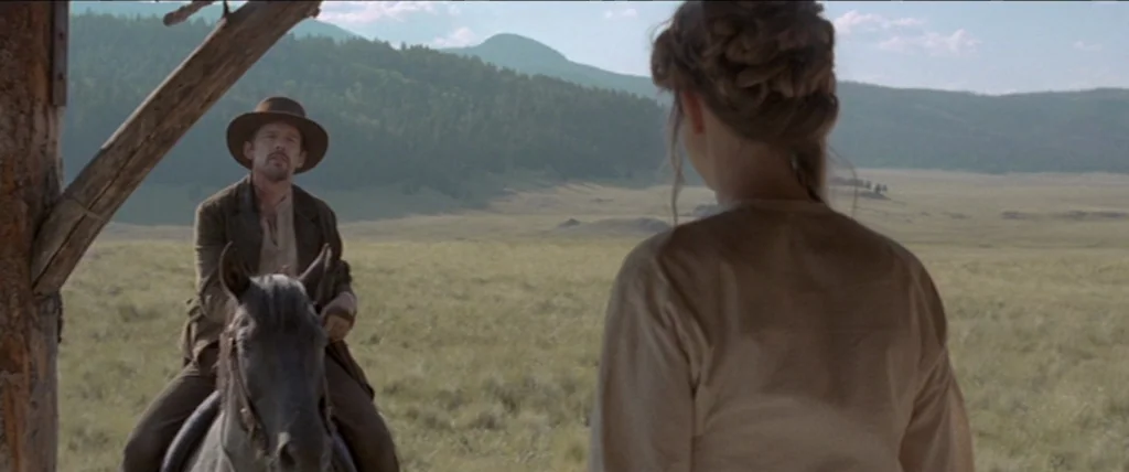In A Valley of Violence (2016) movie still: medium — A vast, dry grassy plain sits before distant hills under a pale sky. A man on a dark horse…
