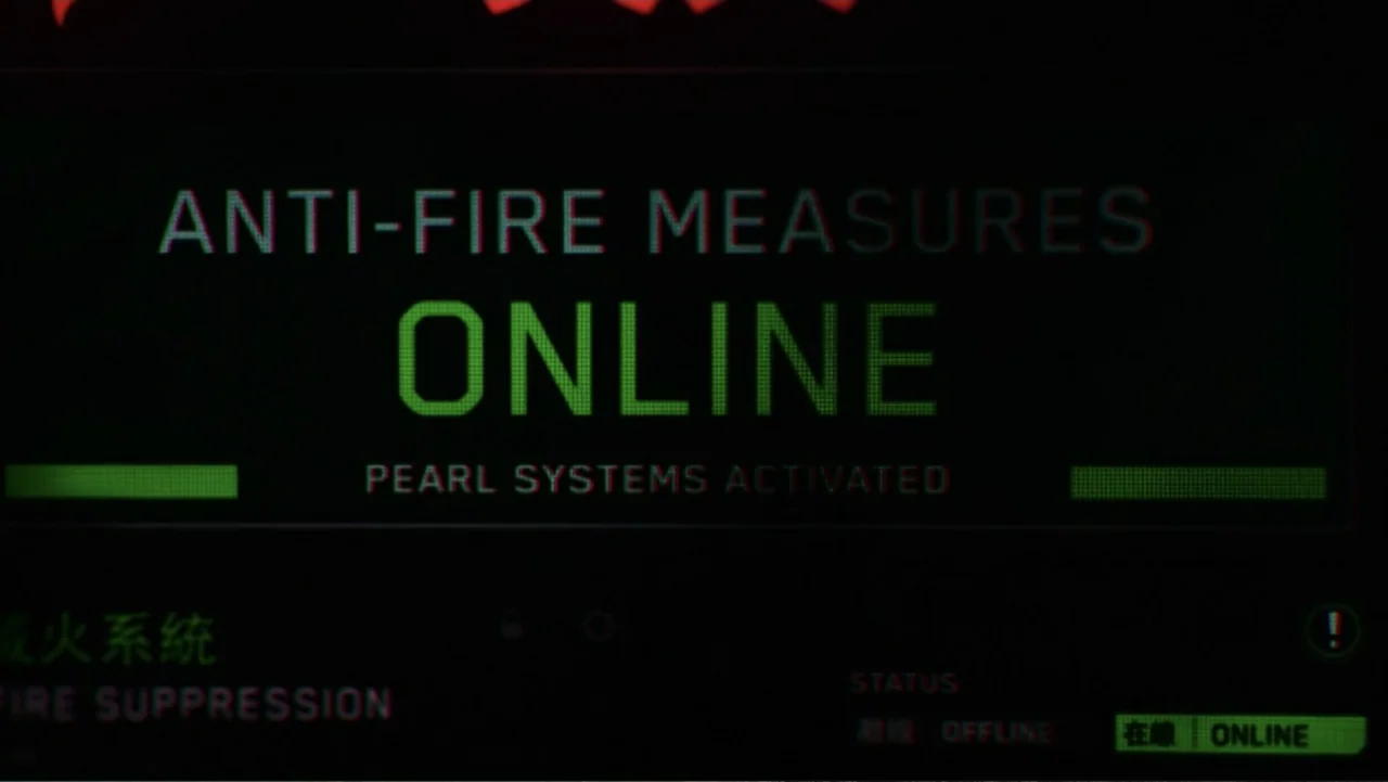 Skyscraper (2018) movie still: closeup — A dark computer interface shows green text indicating that anti-fire measures are online. The screen…