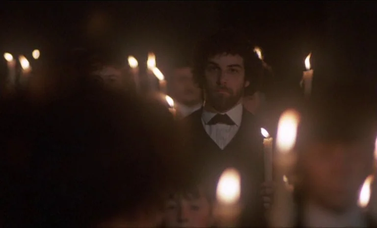 Yentl (1983) movie still: medium — A group of people in 19th-century attire walk through the darkness at night. Each person carries a single lit…