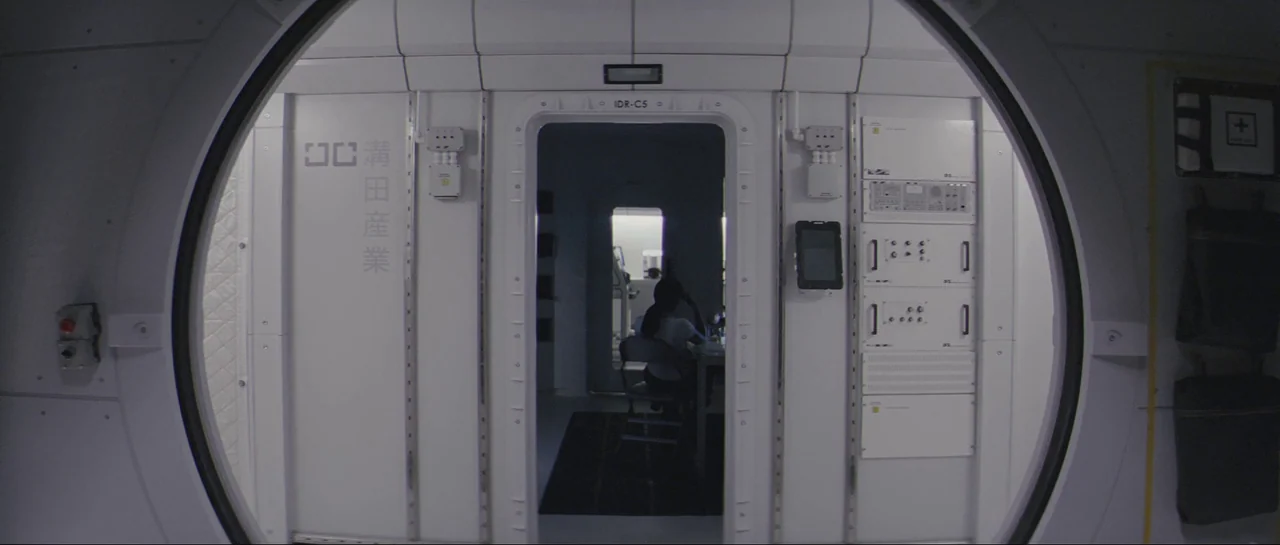 The Last Days On Mars (2013) movie still: wide — A sterile, white modular corridor of a spacecraft with circular doorways and technical equipment. A…