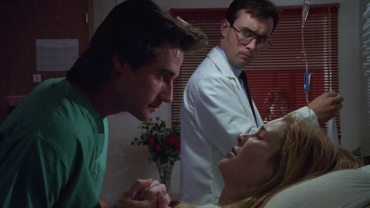 Bride of Reanimator (1989) movie still: medium — A dimly lit hospital room features a woman lying in a bed while two men attend to her. One man…