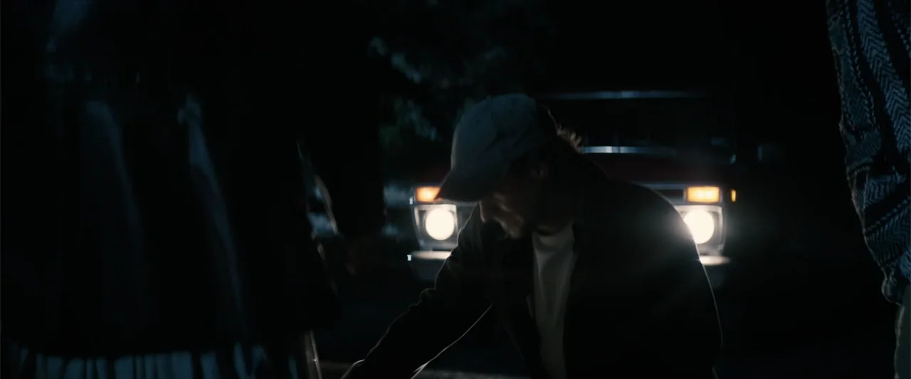 Equation of Love and Tone Deafness (2015) movie still: medium — An outdoor night setting featuring a vintage pickup truck parked in the darkness. A…