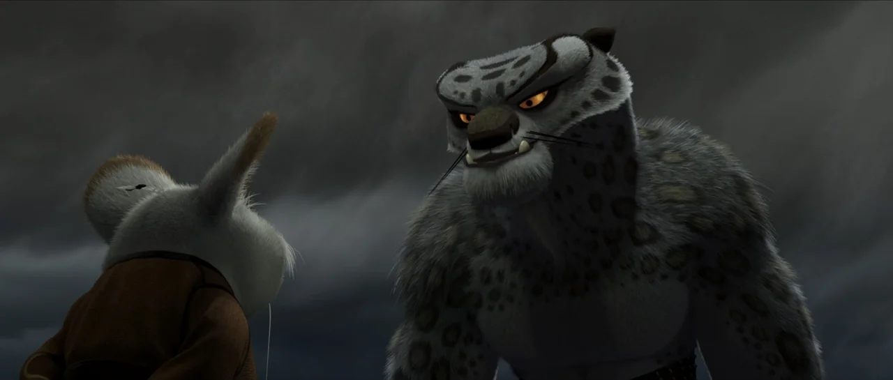 Kung Fu Panda (2008) movie still: medium — A dark and stormy mountain environment features a large snow leopard confronting a smaller character. The…