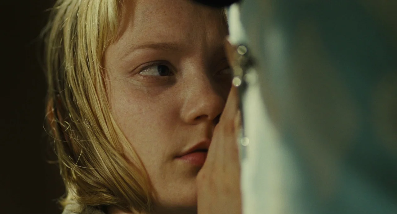 The Double (2013) movie still: closeup — A close portrait of a person against a blurred background. The subject gazes past the camera lens.