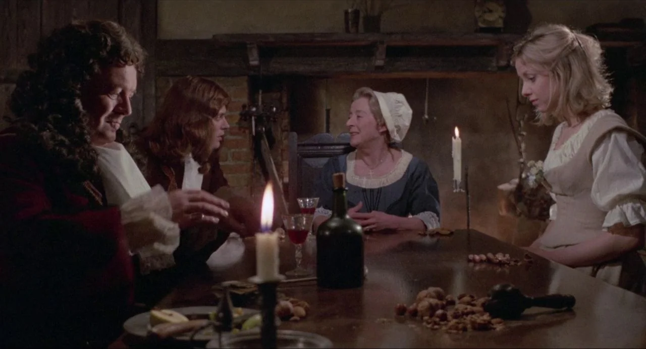 The Blood on Satan’s Claw (1971) movie still: medium — A rustic dining room features a long wooden table illuminated by candlelight. Four people sit…