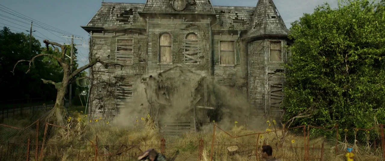 It Chapter Two (2019) movie still: wide — An abandoned two-story wooden house with boarded windows sits behind a rusted iron fence. The porch…