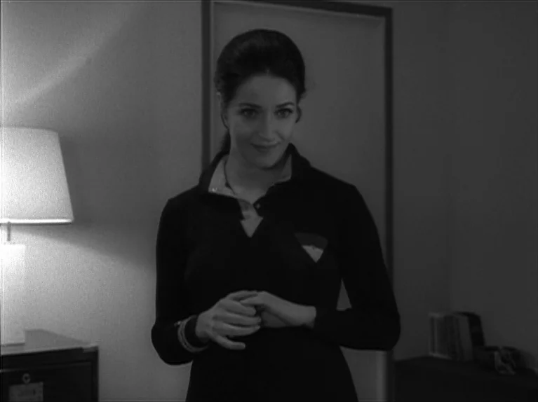 My Night At Maud’s (Ma Nuit Chez Maud) (1969) movie still: medium — A dimly lit office interior contains a desk lamp and a stack of books. A woman…