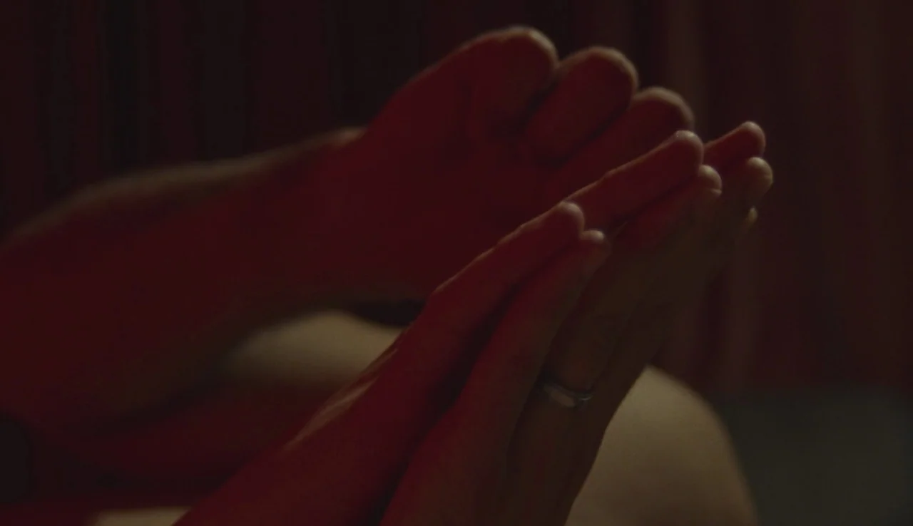 Beach Rats (2017) movie still: closeup — A dimly lit interior space features hands pressed together in a prayer-like gesture. A silver ring is…