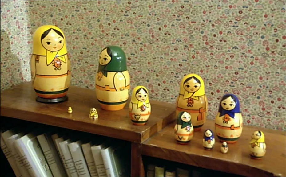 My American Uncle (Mon oncle d’Amérique) (1980) movie still: medium — A wooden shelf with stacked books features a collection of Russian matryoshka…