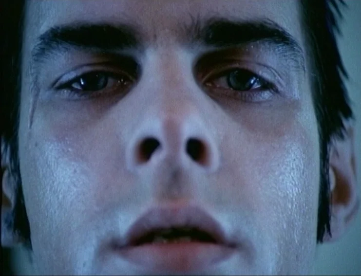 Ghosts… Of The Civil Dead (1988) movie still: closeup — A tight closeup shot focuses on the eyes and bridge of a man's nose. The subject remains…