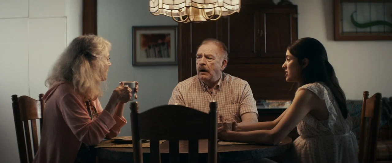 Strange but True (2019) movie still: medium — A residential dining space features a dark wooden table and a decorative glass chandelier. Three…