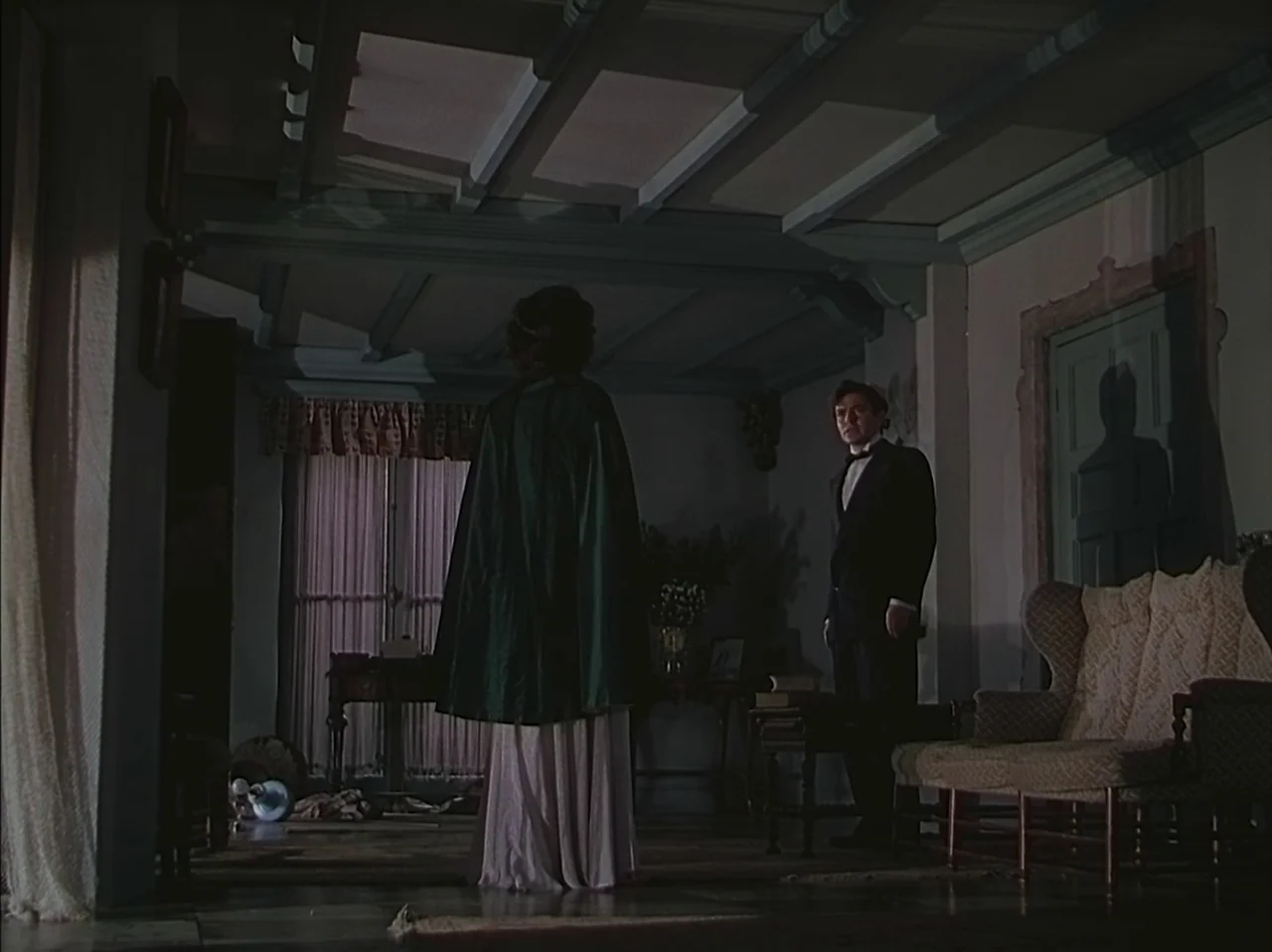 Pandora and the Flying Dutchman (1951) movie still: fullbody — A dimly lit room with exposed ceiling beams and a large window in background. A man…