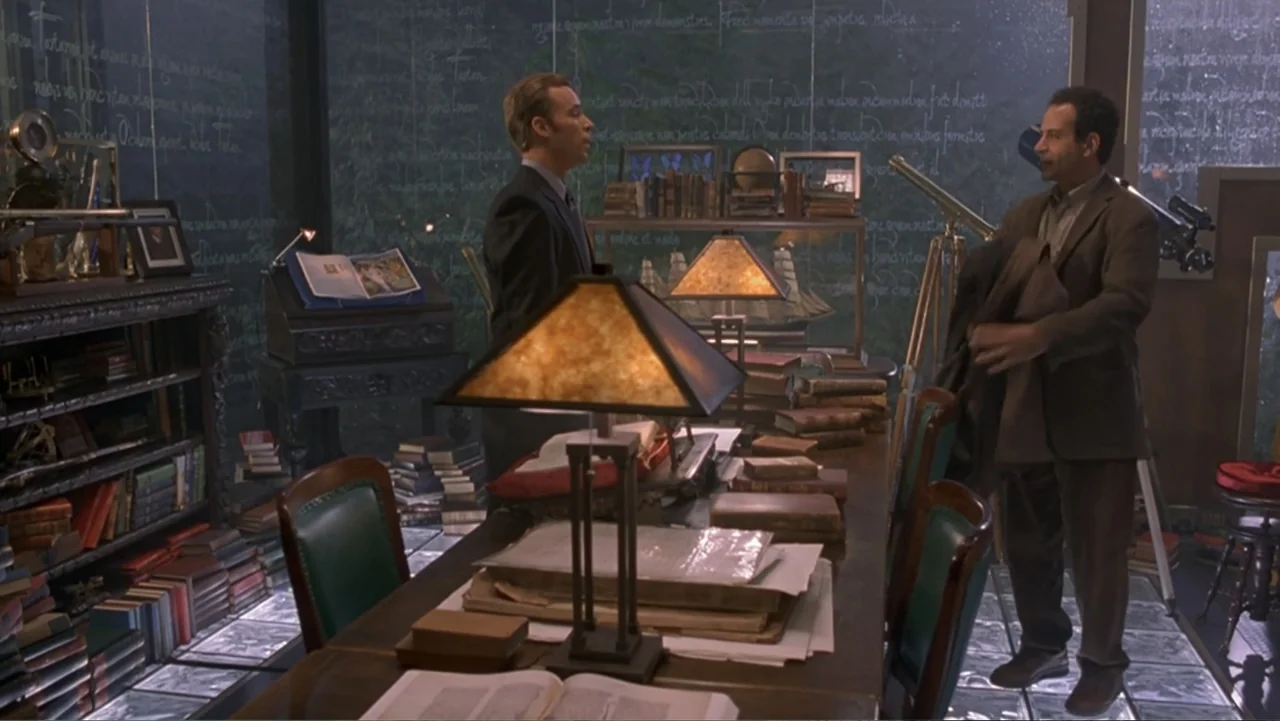 13 Ghosts (1960) movie still: medium — A dark study filled with bookshelves, antique navigation equipment, and large glass-topped desk surfaces. Two…