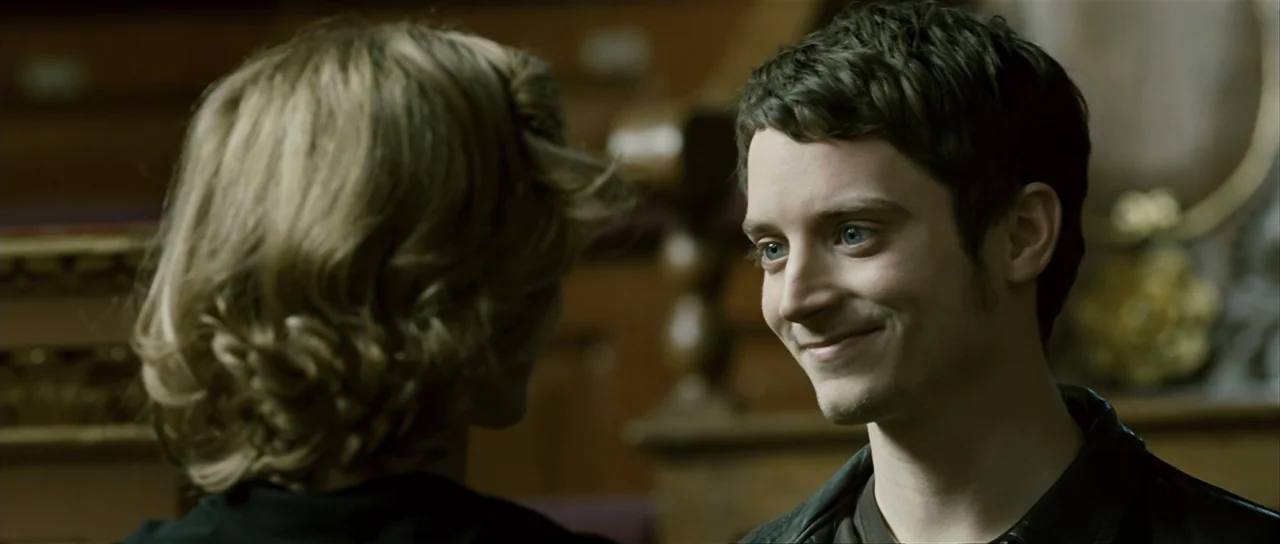 The Oxford Murders (2008) movie still: medium — A dimly lit courtroom features ornate wooden panels and benches in the background. A young man with…