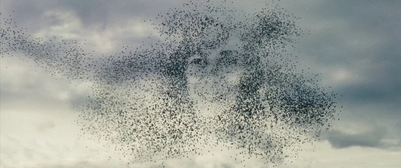The Secret Life of Walter Mitty (2013) movie still: establishing — An overcast sky with layered grey and white clouds fills the wide frame. A dense…