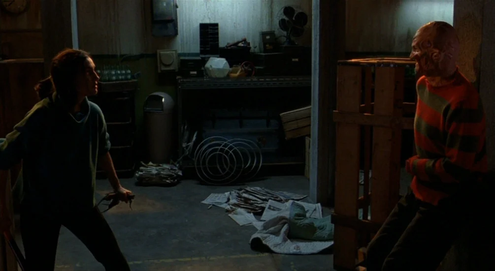 Freddy’s Dead: The Final Nightmare (1991) movie still: medium — A dimly lit basement features concrete walls, scattered papers, and industrial…
