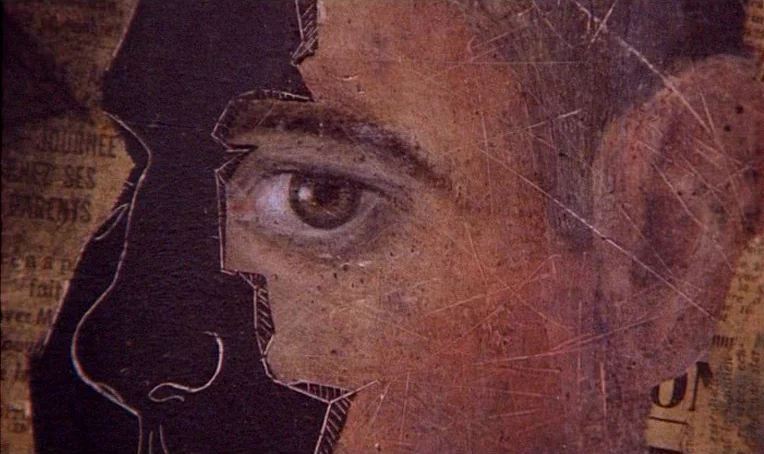 Jacquot de Nantes (1991) movie still: closeup — A close-up view of a mixed-media collage featuring newspaper fragments and a printed face. The…