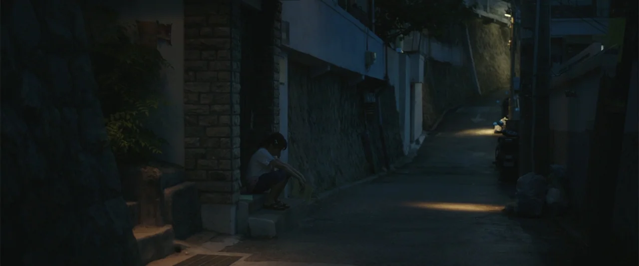 Along with the Gods: The Two Worlds (2017) movie still: wide — A dark narrow residential alleyway at night bordered by high stone retaining walls. A…