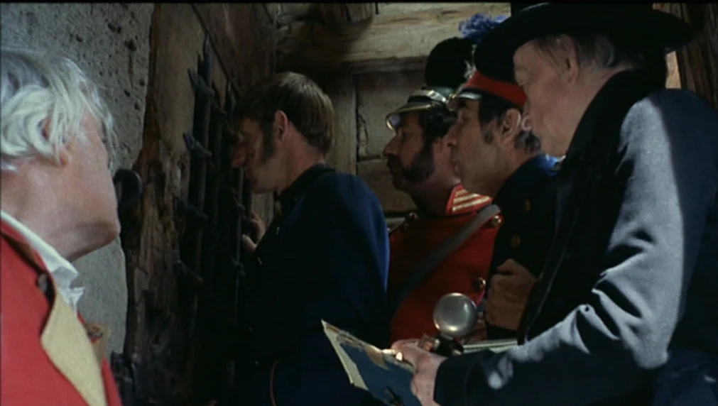 The Enigma Of Kaspar Hauser (1974) movie still: medium — A group of men in diverse 19th-century military uniforms stand in a stone passage. They…