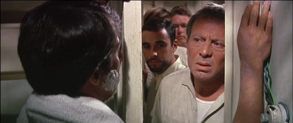 The Graduate (1967) movie still: medium — A cramped washroom setting with plain white walls and visible exposed electrical wiring details. Two men…