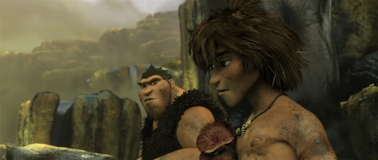 The Croods (2013) movie still: medium — A hazy prehistoric environment with rocky formations and soft sunlight filtering through air. Two men stand…
