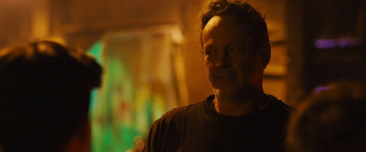 Freaky (2020) movie still: medium — A dimly lit indoor space with indistinct background elements blurred by shallow depth of field. A middle-aged…