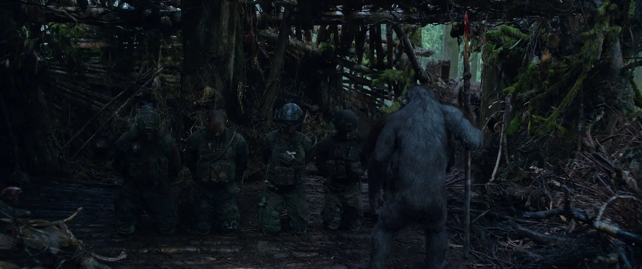 War for the Planet of the Apes (2017) movie still: fullbody — A makeshift shelter constructed from woven branches and logs creates a dark, enclosed…