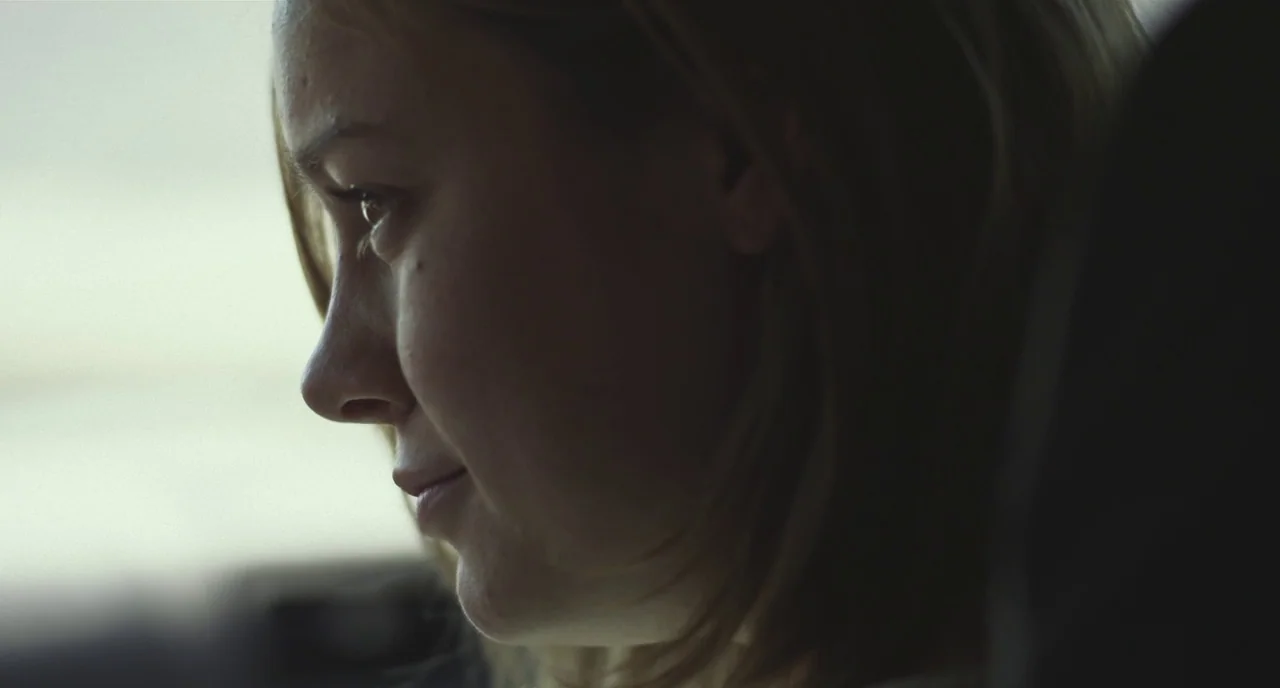 Short Term 12 (2013) movie still: closeup — A vehicle interior with soft ambient light coming through a side window. A young woman looks out the…