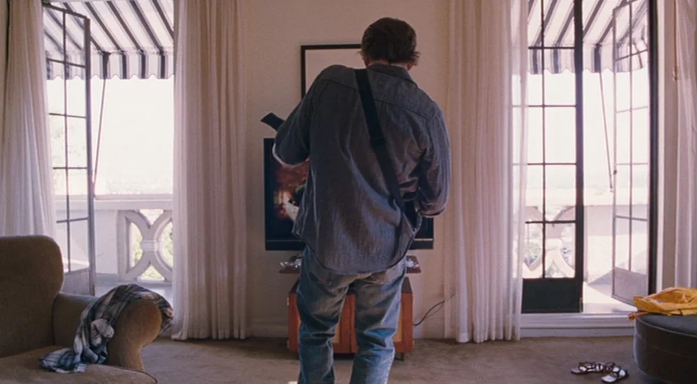 Somewhere (2010) movie still: fullbody — A hotel suite features beige carpet and two sets of tall French doors. A man stands in the center of the…