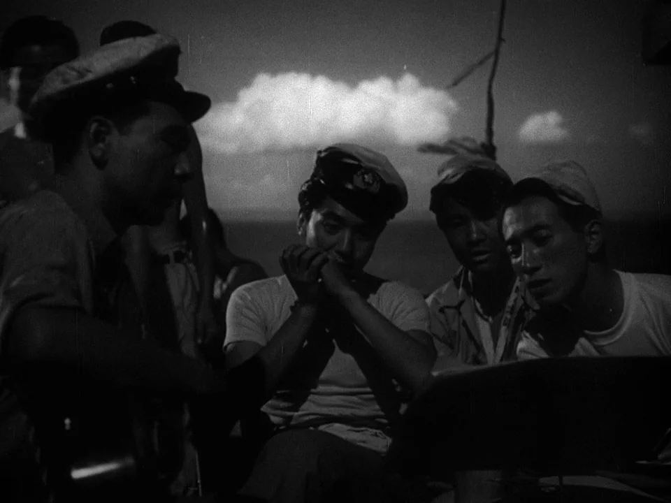 Godzilla (1954) (1954) movie still: medium — A group of men in military attire congregate on the deck of a ship. They gather around a music stand to…