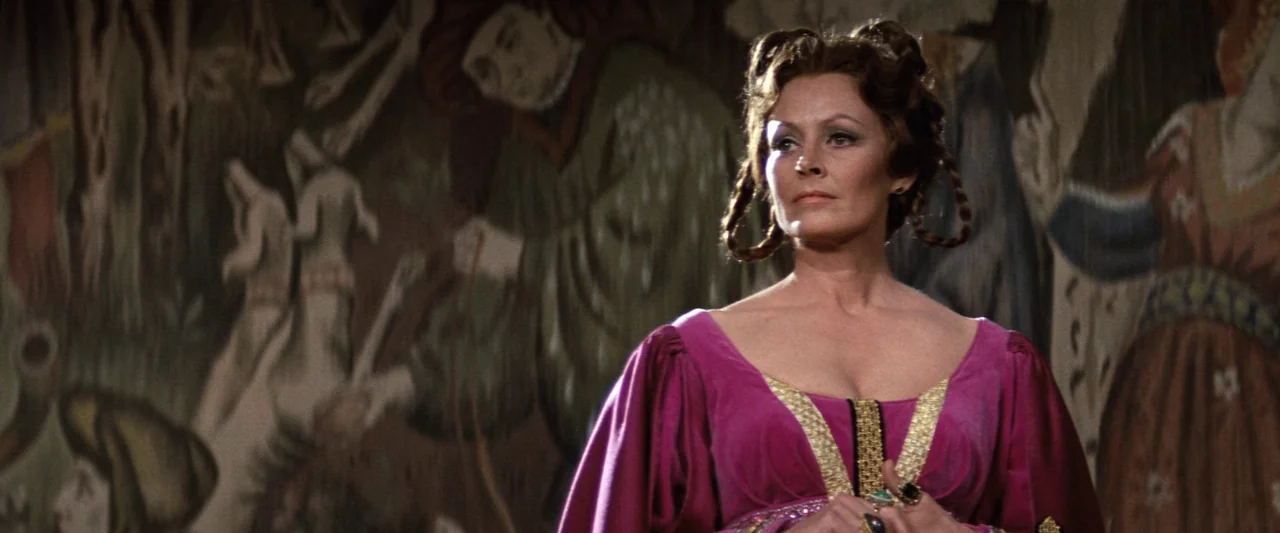 Westworld (1973) movie still: medium — A stone room featuring a large, intricate tapestry depicting medieval figures behind the subject. A woman…
