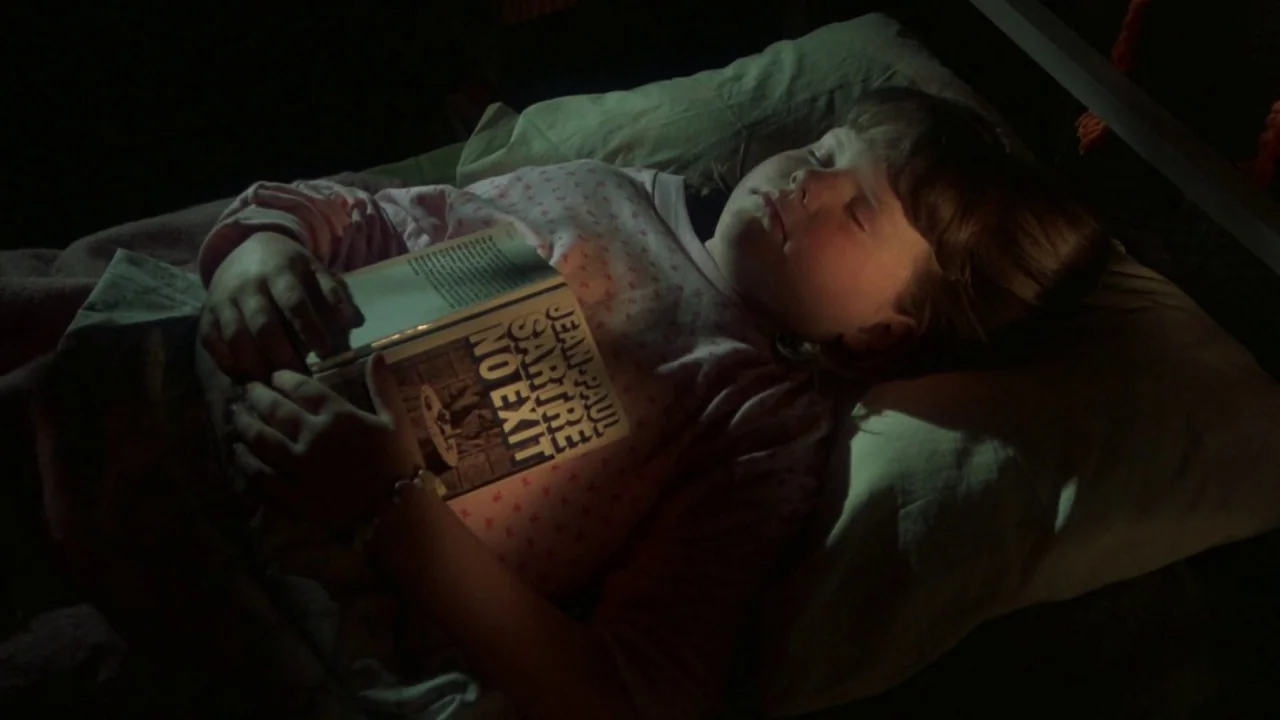 Friday the 13th Part VI: Jason Lives (1986) movie still: medium — A young girl sleeps in a dark bedroom under soft blankets. She holds a copy of…