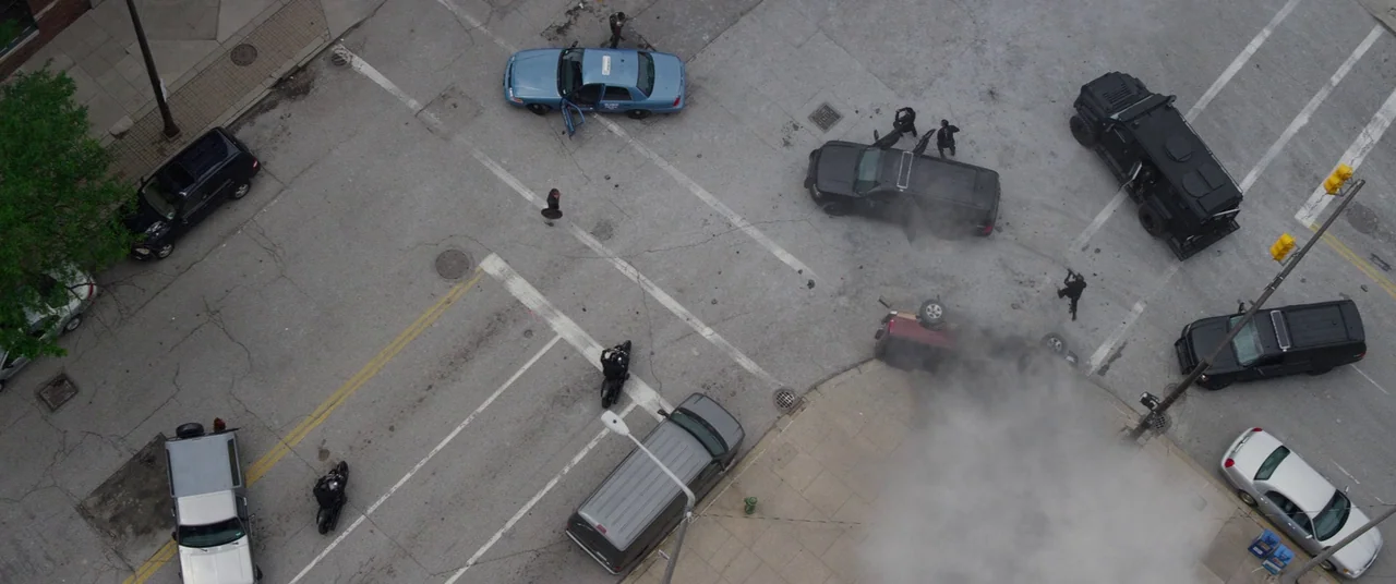 Captain America: The Winter Soldier (2014) movie still: wide — An urban intersection with white lane markings and asphalt. Several black tactical…