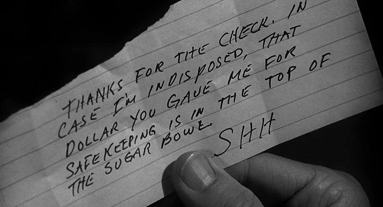 Dead Men Don’t Wear Plaid (1982) movie still: closeup — A piece of torn, lined notebook paper is held by a person's thumb. The paper contains black…