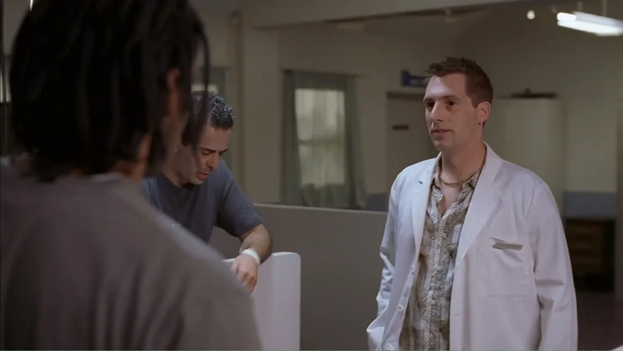 Day of the Dead 2: Contagium (2005) movie still: medium — A sterile medical room with clinical partitioning and neutral wall colors. A doctor in a…