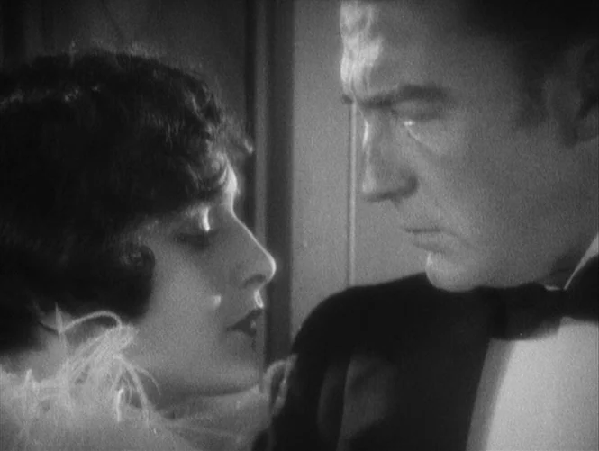 Underworld (1927) movie still: closeup — An interior space features two individuals positioned closely within a high-contrast setting. A man in…