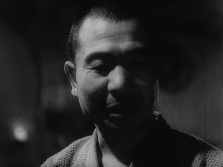 Sanshiro Sugata Part II (1945) movie still: closeup — A dimly lit indoor space with heavy shadows cast over the subject. An East Asian man faces…