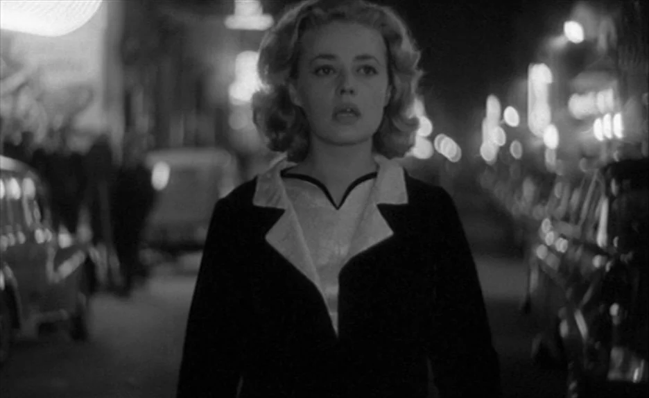 Elevator To The Gallows (Ascenseur pour l’échafaud) (1958) movie still: medium — A woman walks through a dark, urban street at night with blurred…