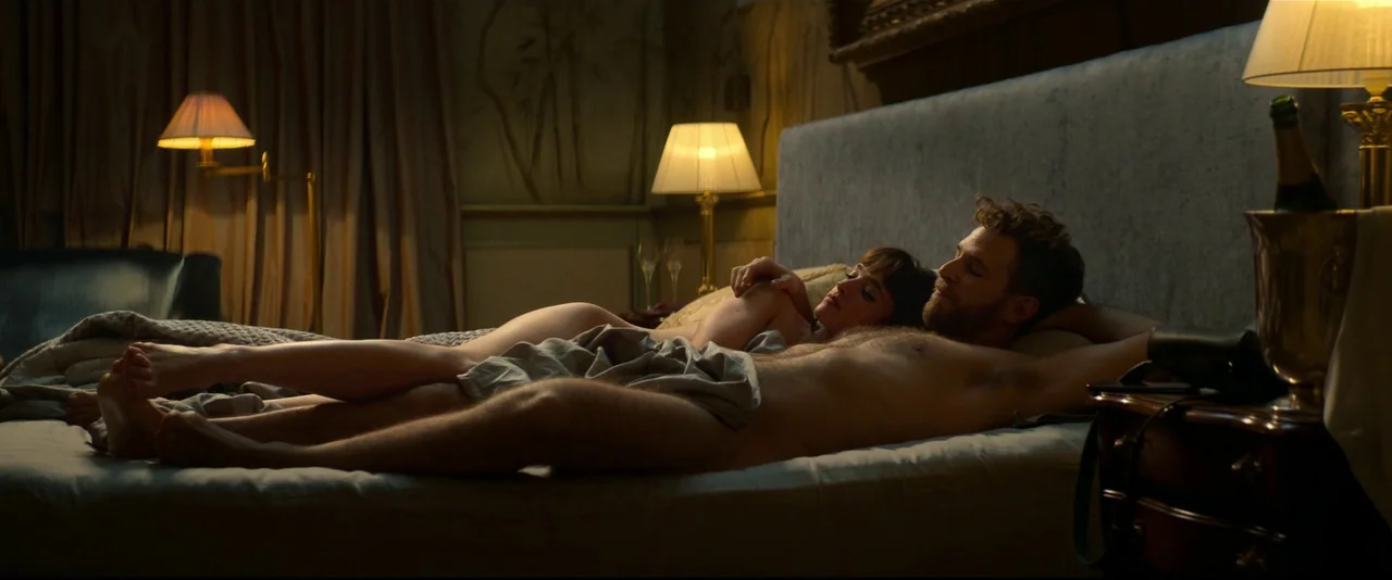 Crazy About Her (2021) movie still: medium — An upscale room features a large upholstered headboard and two illuminated bedside lamps. A man and…