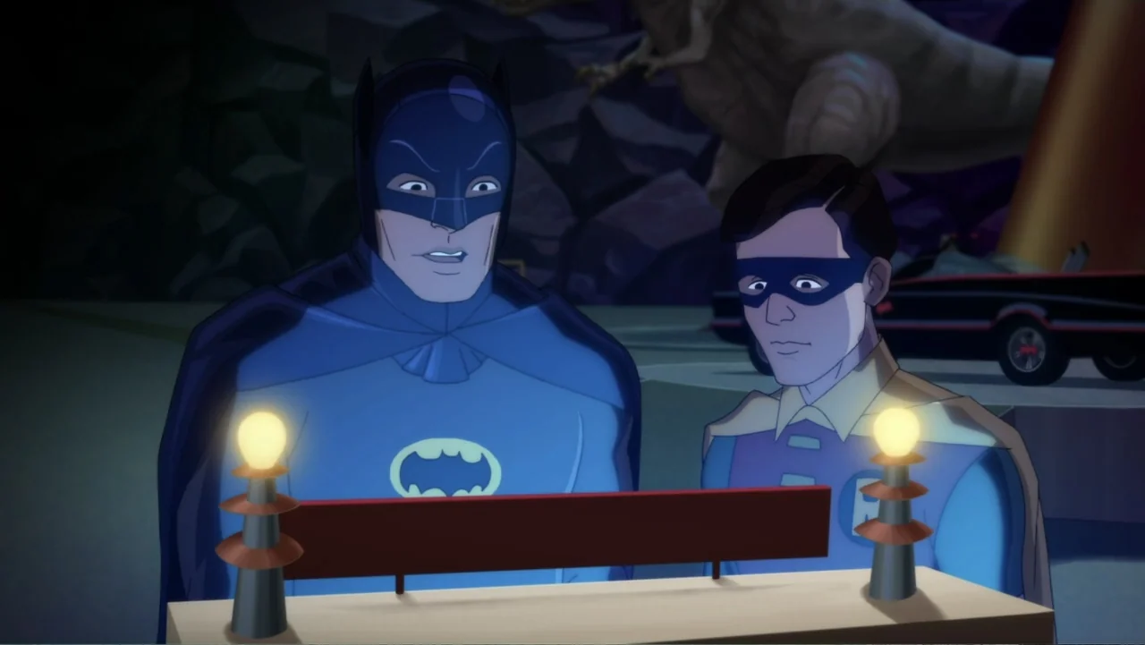 Batman: Return of the Caped Crusaders (2016) movie still: medium — A dark, stylized interior laboratory contains a wooden workbench with two small…