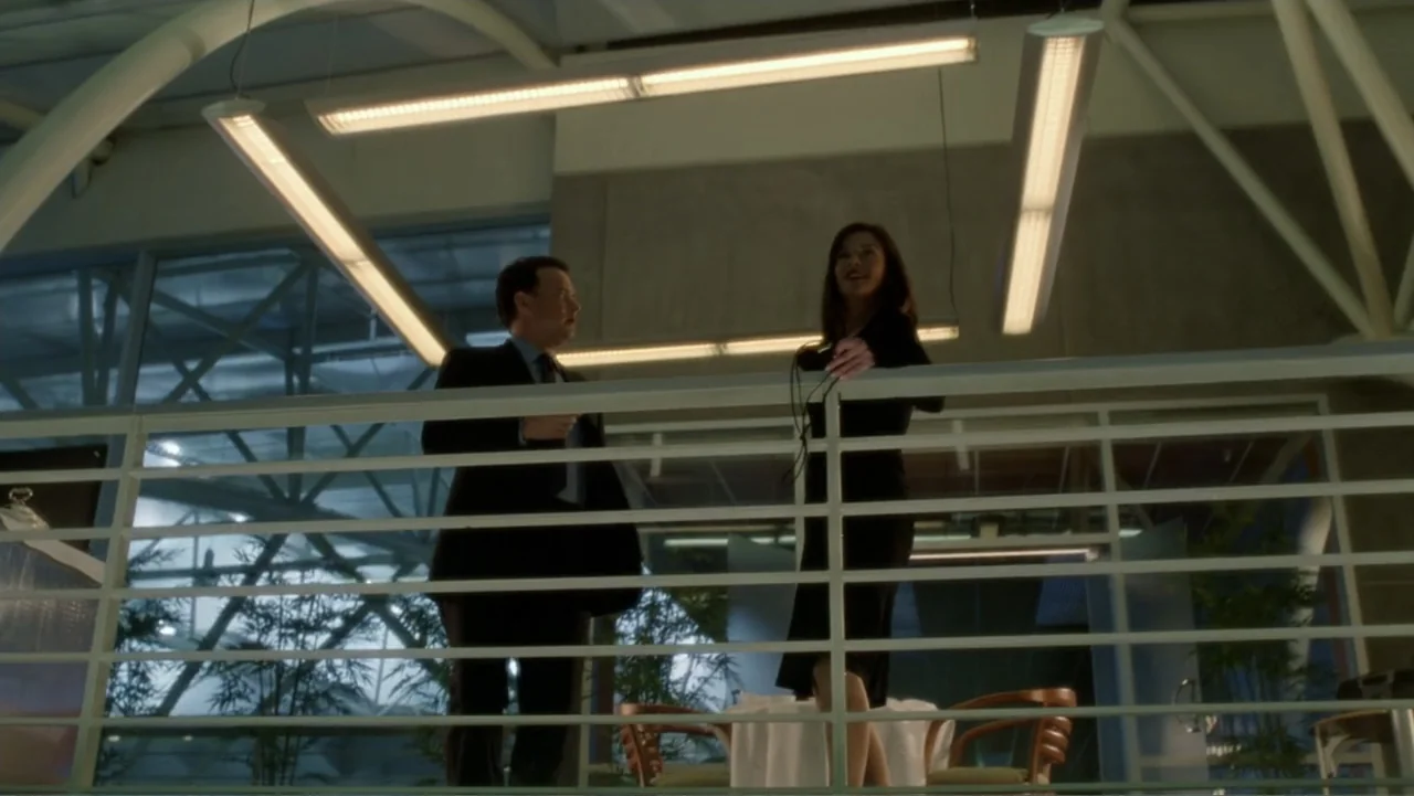 The Terminal (2004) movie still: medium — A modern mezzanine level overlooks a large glass-walled airport terminal with structural white beams. A…