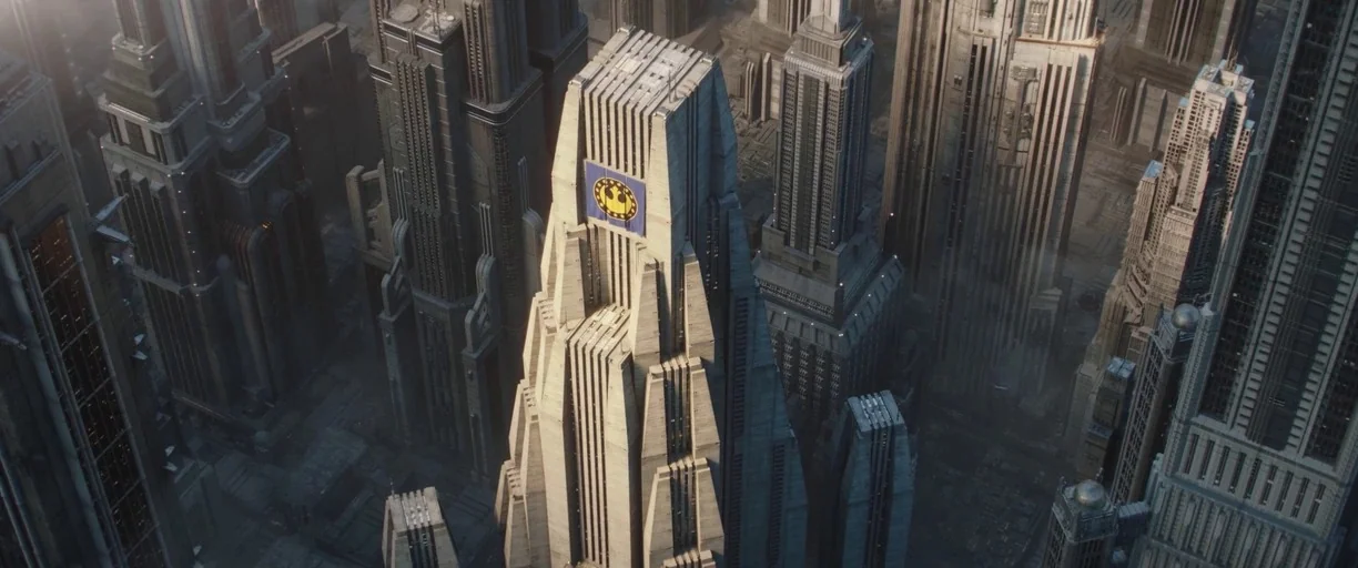 The Mandalorian (2019) movie still: establishing — A dense urban landscape of towering concrete skyscrapers features an art deco aesthetic. A large…