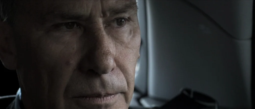 Down Terrace (2009) movie still: closeup — A close-up of an elderly man inside a moving car. He looks away from the camera through a window.