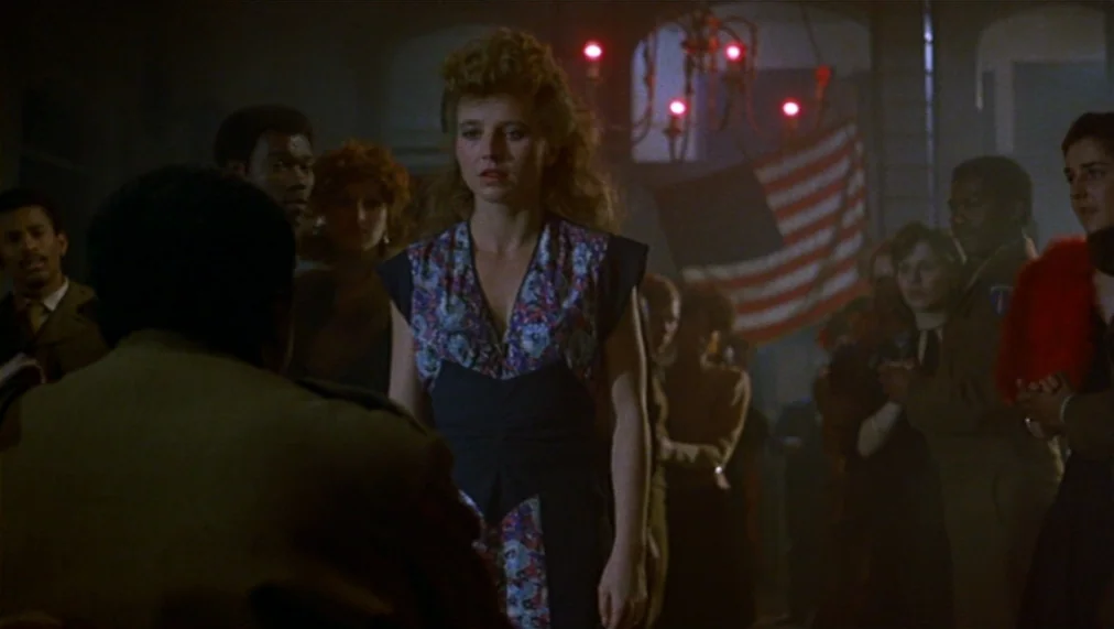 The Marriage of Maria Braun (1979) movie still: medium — A dimly lit ballroom features a crowd of people standing beneath chandeliers. An American…