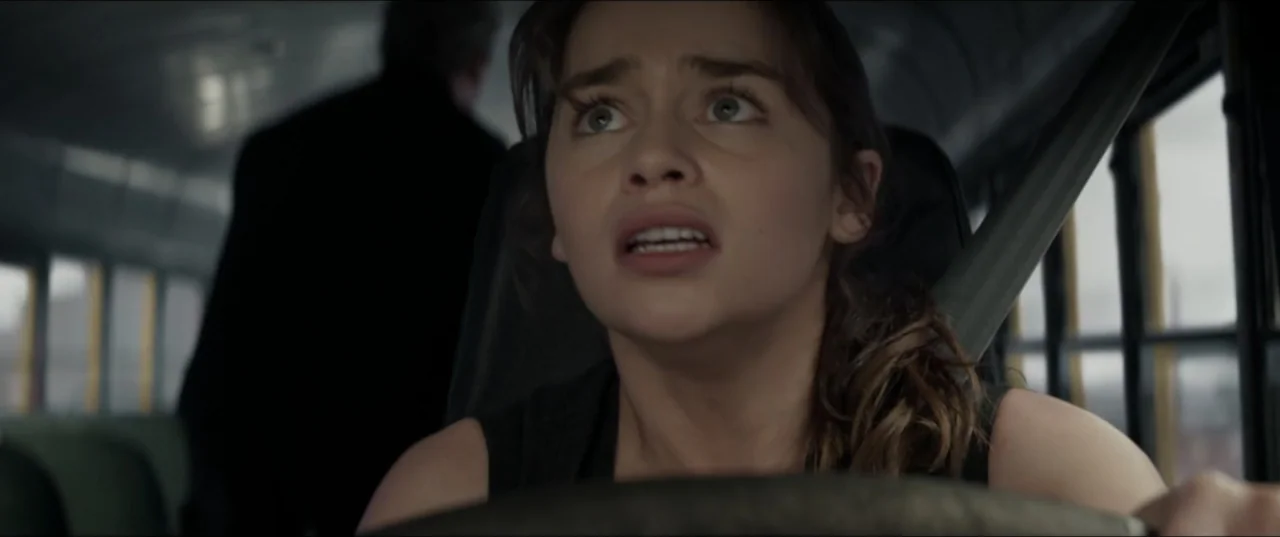 Terminator Genisys (2015) movie still: closeup — A woman drives a public transport bus with windows lining the interior walls. She grips the…