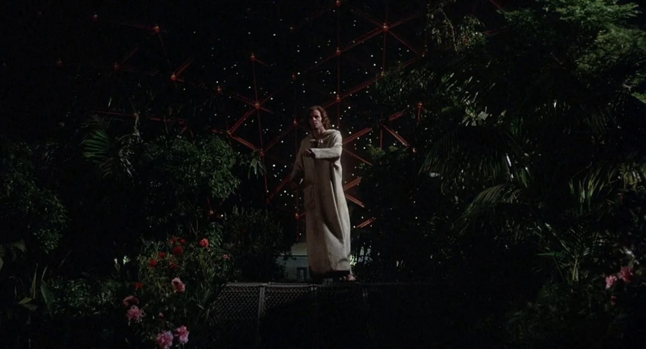 Silent Running (1972) movie still: fullbody — A dark indoor space contains dense green foliage and a large geometric metal structure. A single man…