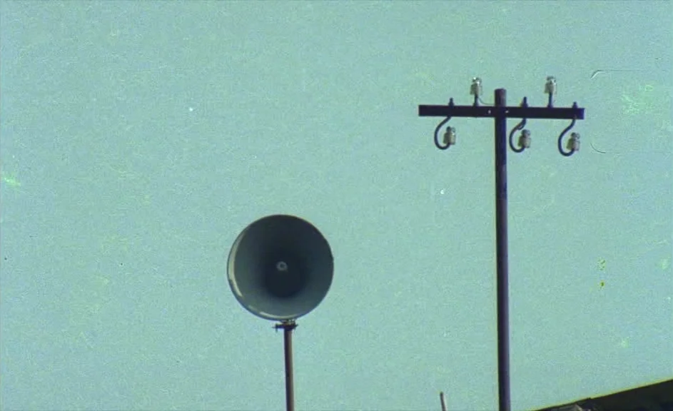 The Kingdom of Naples (1978) movie still: wide — A vintage metal loudspeaker and a utility pole stand against a featureless sky. The scene shows…