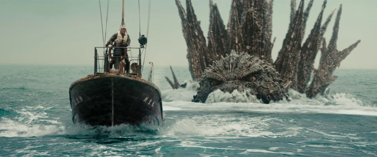 Godzilla Minus One (2023) movie still: wide — An open expanse of churning ocean with a small wooden fishing vessel navigating forward. A giant…