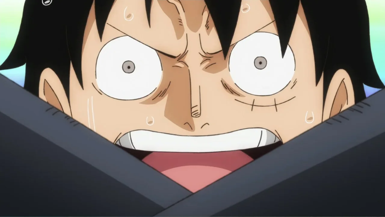 One Piece Film Red (2022) movie still: closeup — A close-up of an anime character's face against a blurred colorful background. The character has…